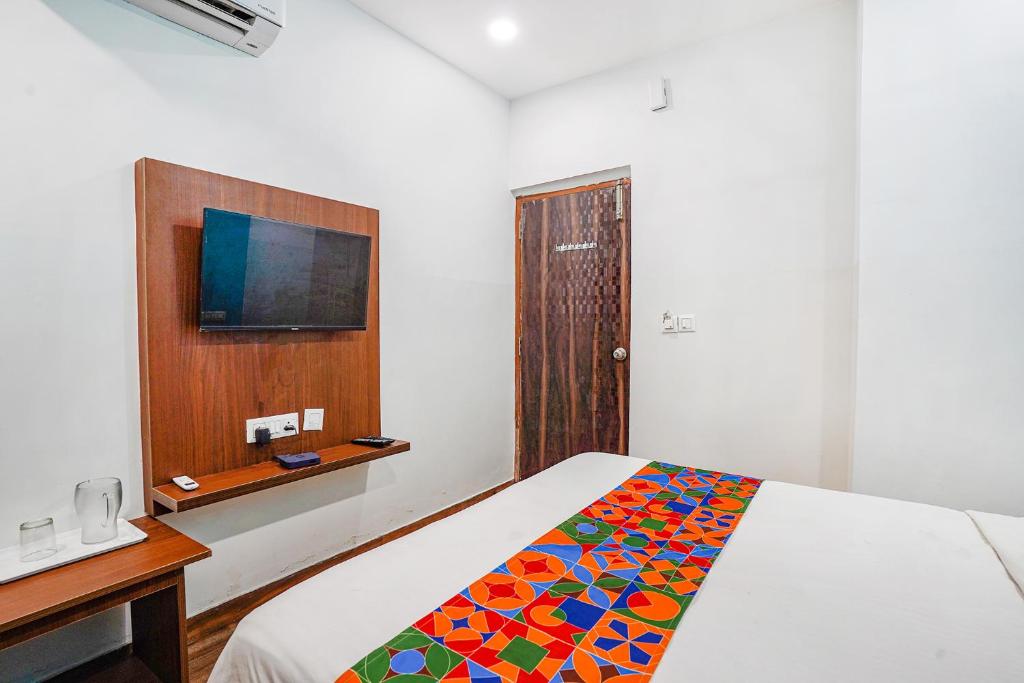 a bedroom with a bed with a colorful blanket on it at Hotel RLV Green Palace - Nr Kengeri Satellite Town in Bengaluru