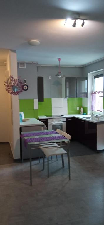 a kitchen with a purple table in a room at Pepe Apartment 40 mkw in Szczecin
