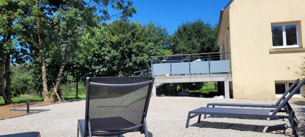 a chair and a bench in front of a building at Breizh Villa in Landivisiau