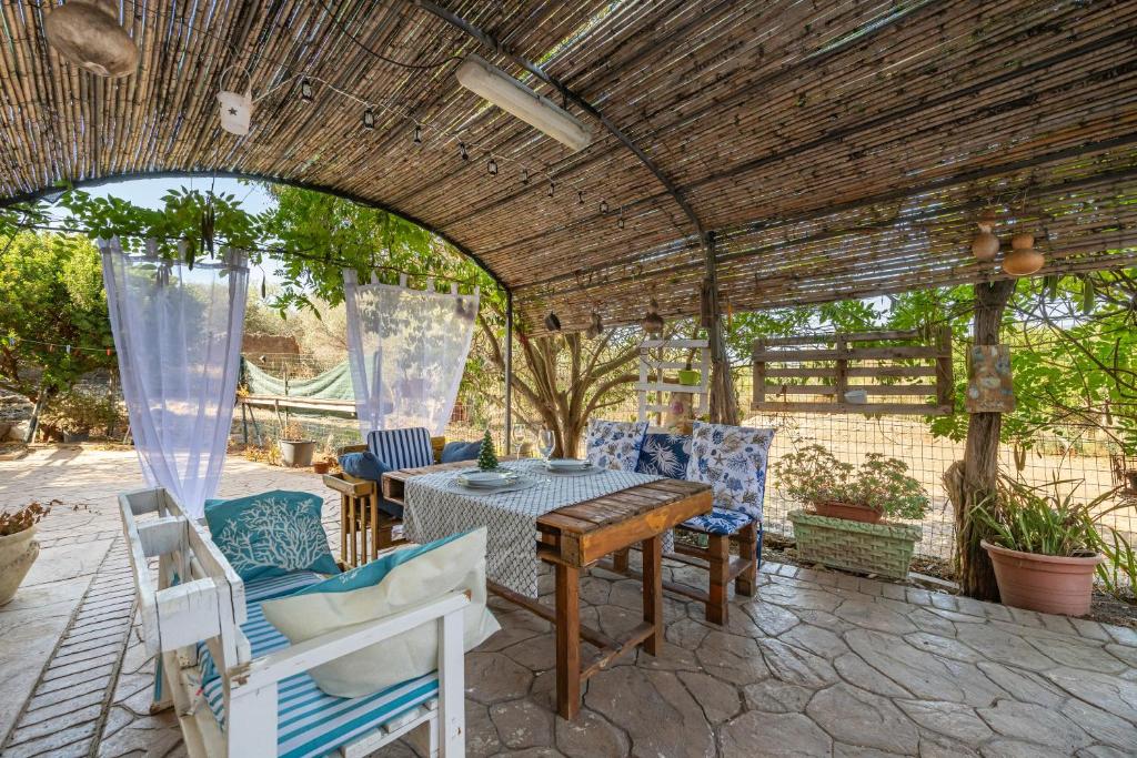 un patio avec une table et des chaises sous une pergola dans l'établissement Casa Francesca, à Villa San Pietro
