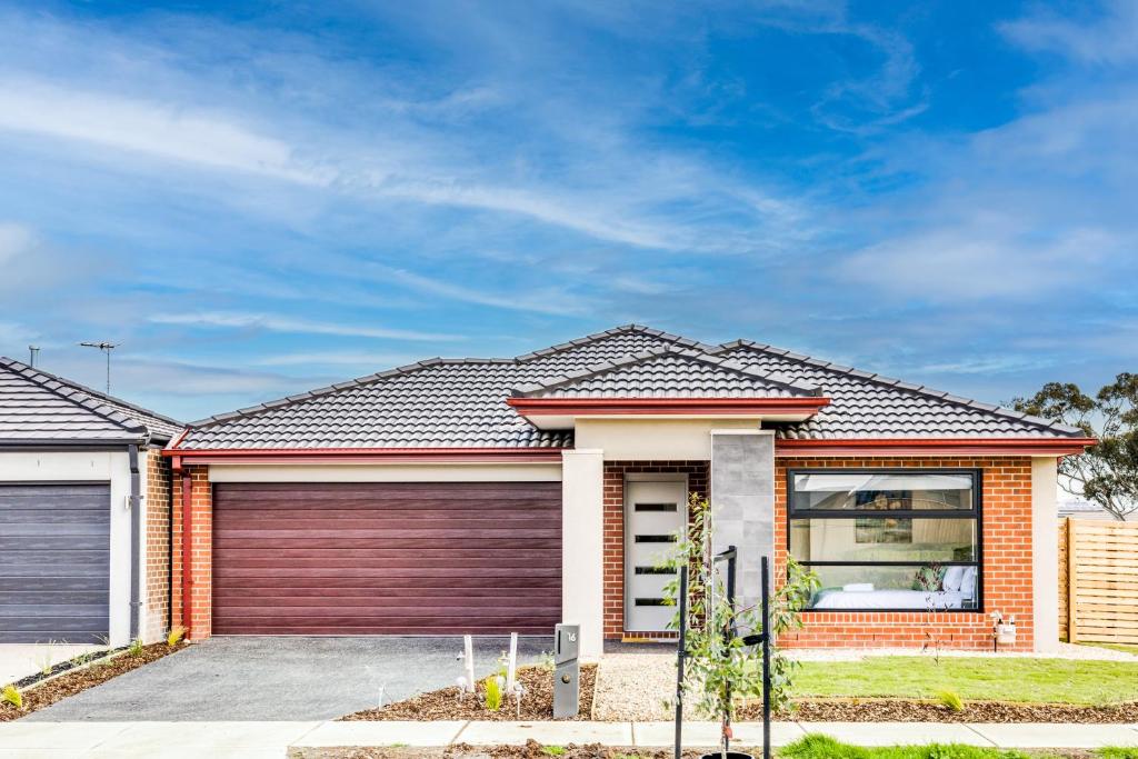 a brick house with a garage at StayAU Charming 4BR Retreat in Wyndham Vale in Wyndham Vale