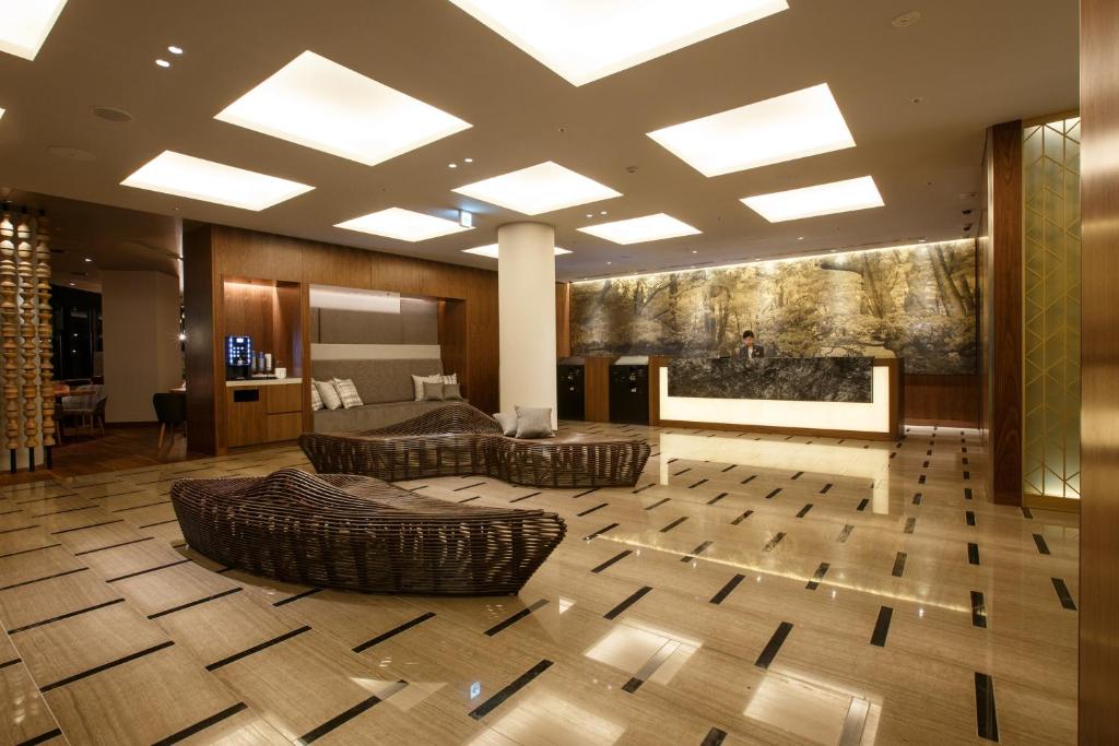 a lobby with a large room with couches and a bed at Hotel Forza Kanazawa in Kanazawa