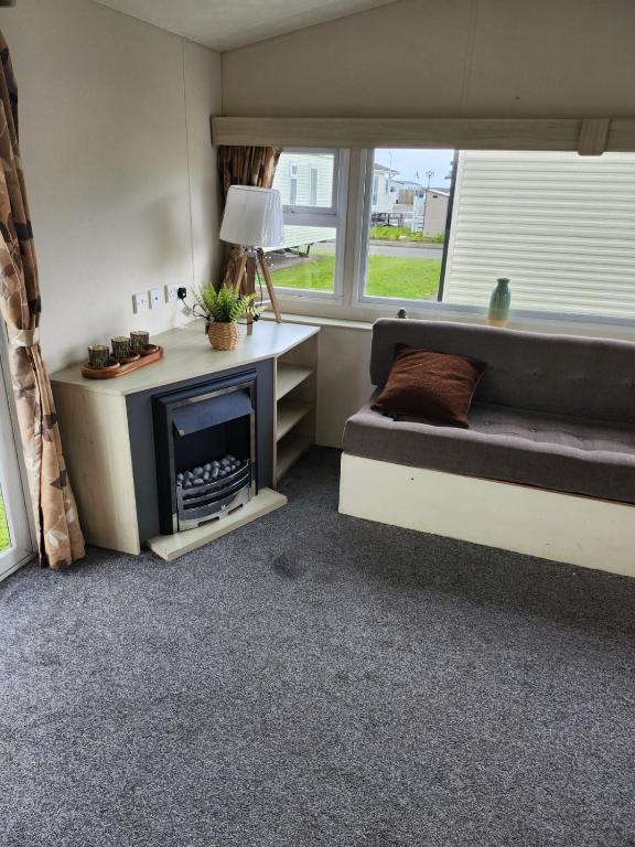 a living room with a couch and a fireplace at 20 Cherry Tree Walk Lyons Robin Hood in in Rhyl
