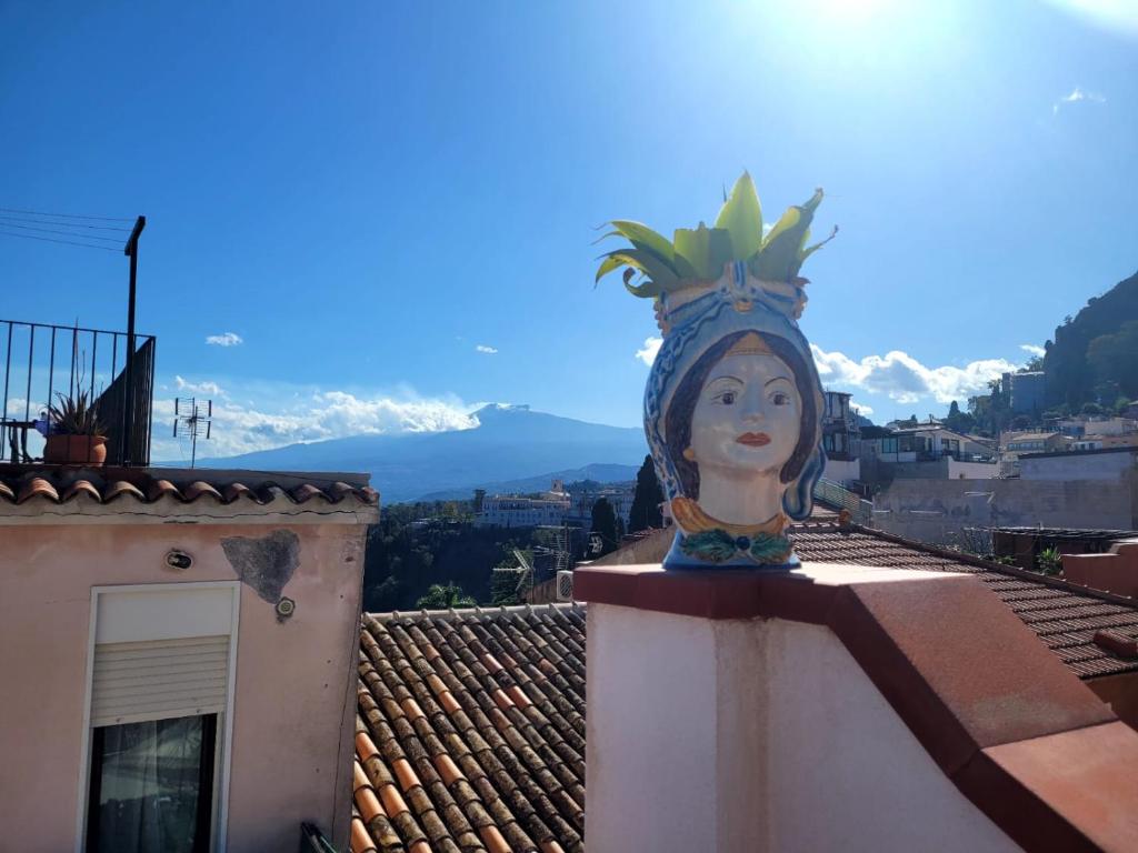 a statue of a woman on top of a building at Casa MAIO, attico molto panoramico, in centro storico in Taormina