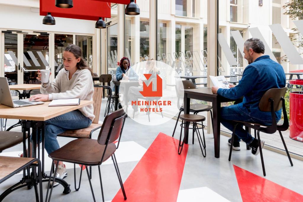 波尔多MEININGER Hotel Bordeaux Gare Saint-Jean的一群人坐在餐厅的桌子旁