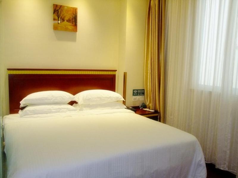 a large white bed in a room with a window at GreenTree Inn Shandong Weifang Wanda Plaza Yuhe Road Express Hotel in Weifang