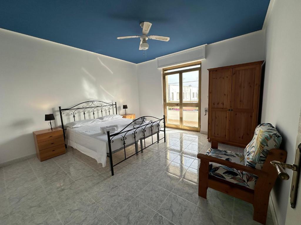 a bedroom with a bed and a ceiling fan at EMMA Appartamento Lido Marini in Lido Marini