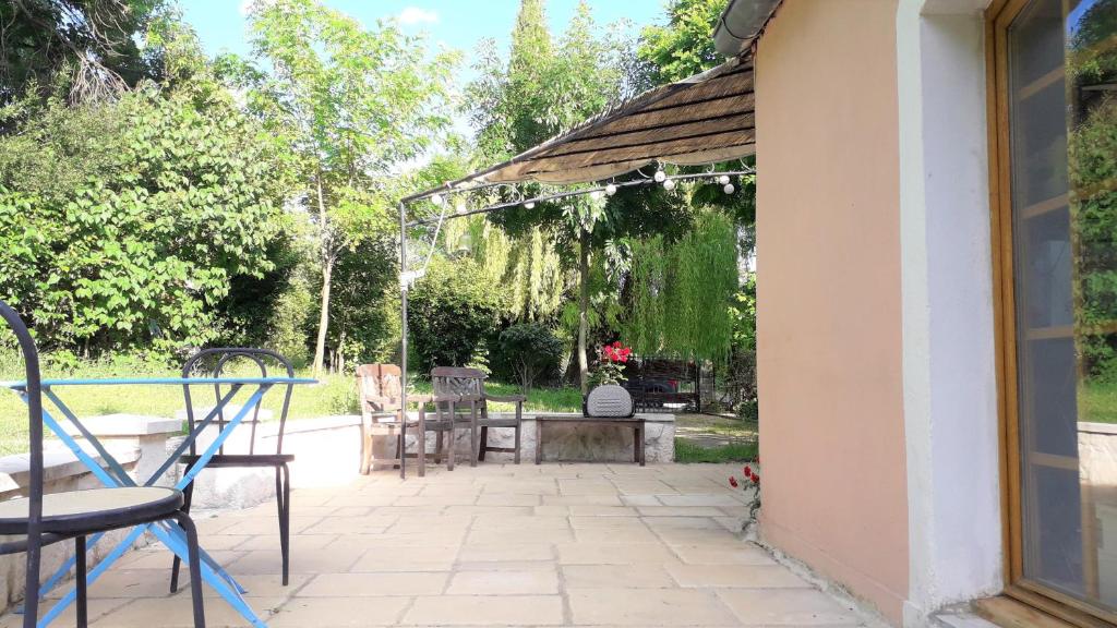Un patio con sillas y un cenador. en Au coeur des arbres, en Dieulefit
