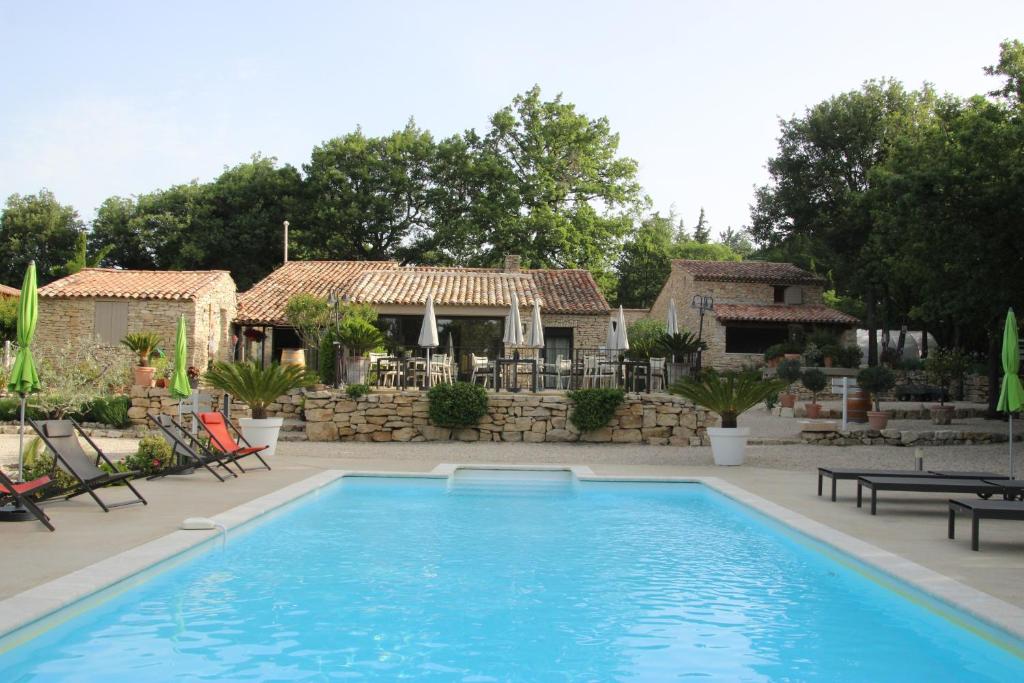 une grande piscine devant une maison dans l'établissement Gîte Pèbre d'aï avec Piscine Partagée, à Gordes