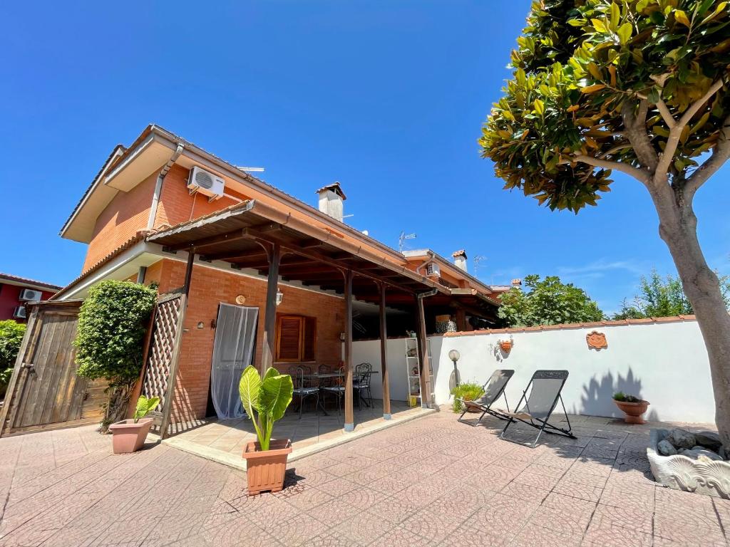 a house with a patio and a tree at Villa Marina in Torvaianica