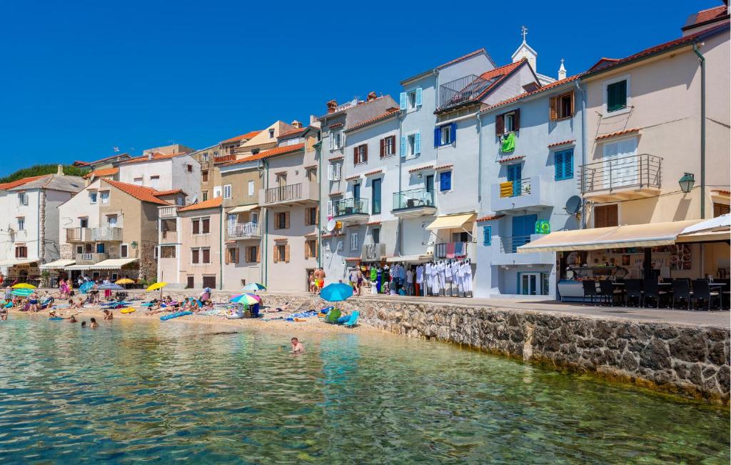 a group of people on a beach in the water at 1 Bedroom Nice Apartment In Baska in Baška