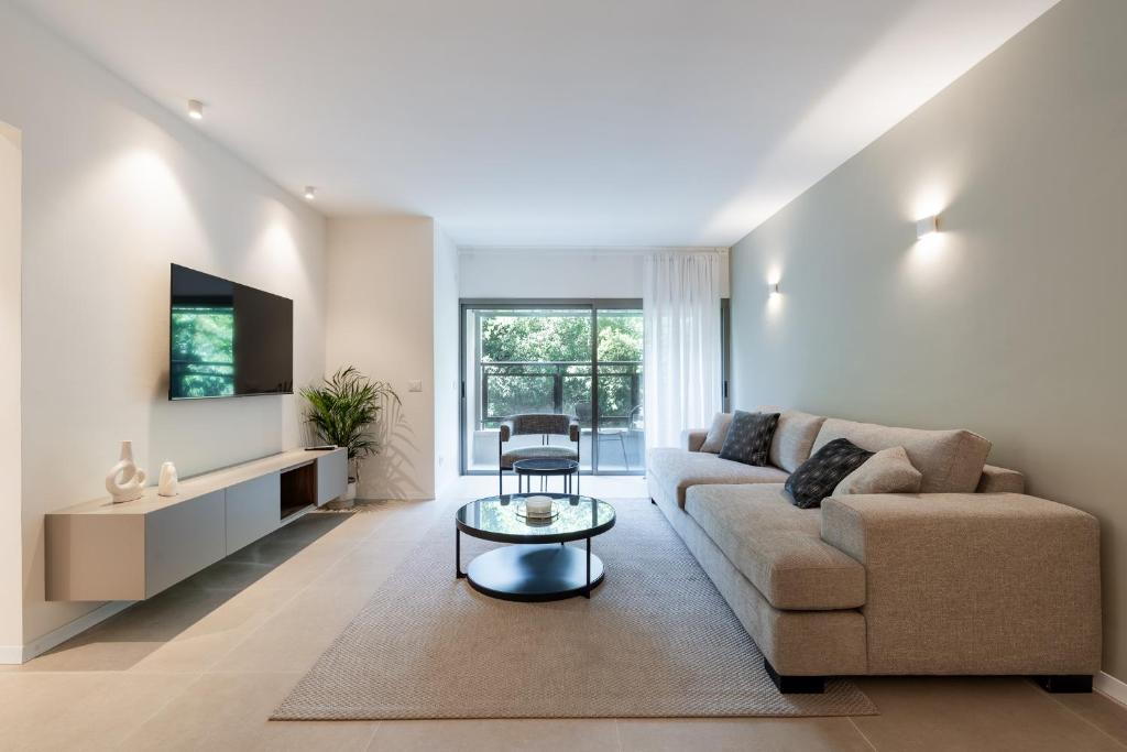 a living room with a couch and a table at Dizengoff Deluxe Retreat in Tel Aviv