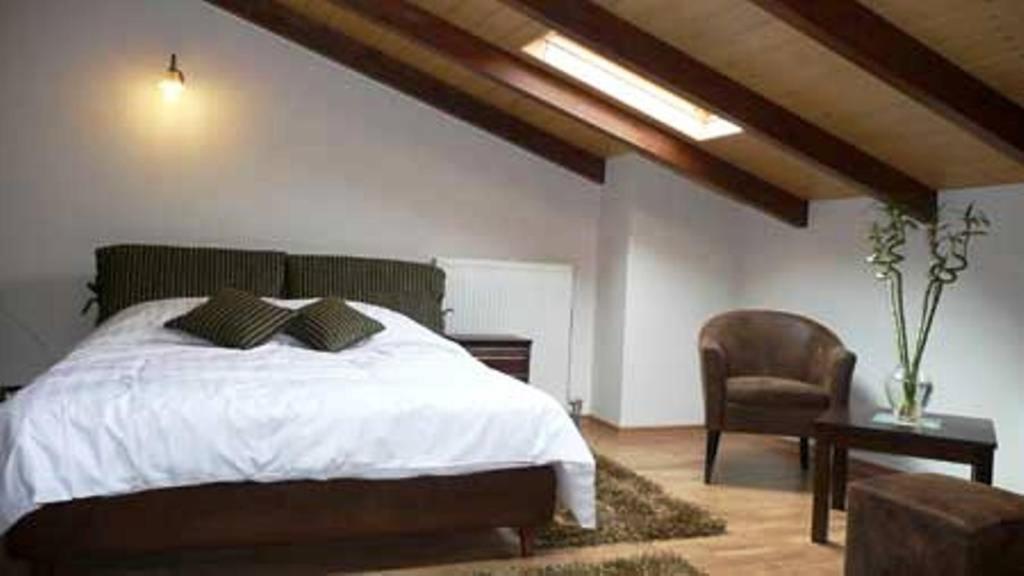 - une chambre avec un grand lit et une chaise dans l'établissement Siarava, à Ioannina