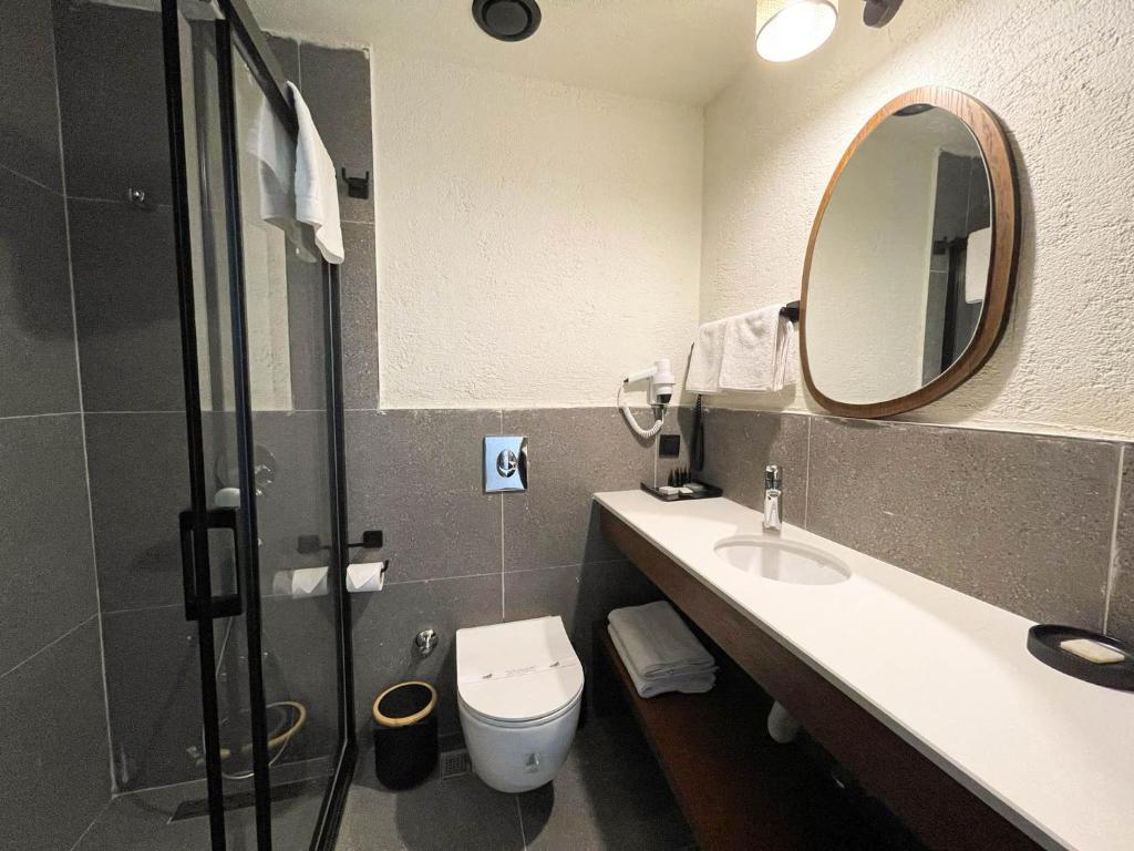 a bathroom with a sink and a mirror and a toilet at Now Boutique Hotel in Erdemli