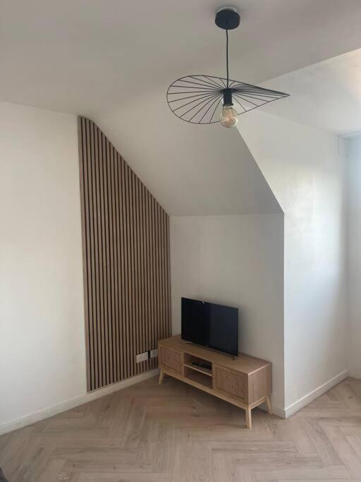 un salon avec une télévision sur une table en bois dans l'établissement Hennebont côté gare, à Hennebont