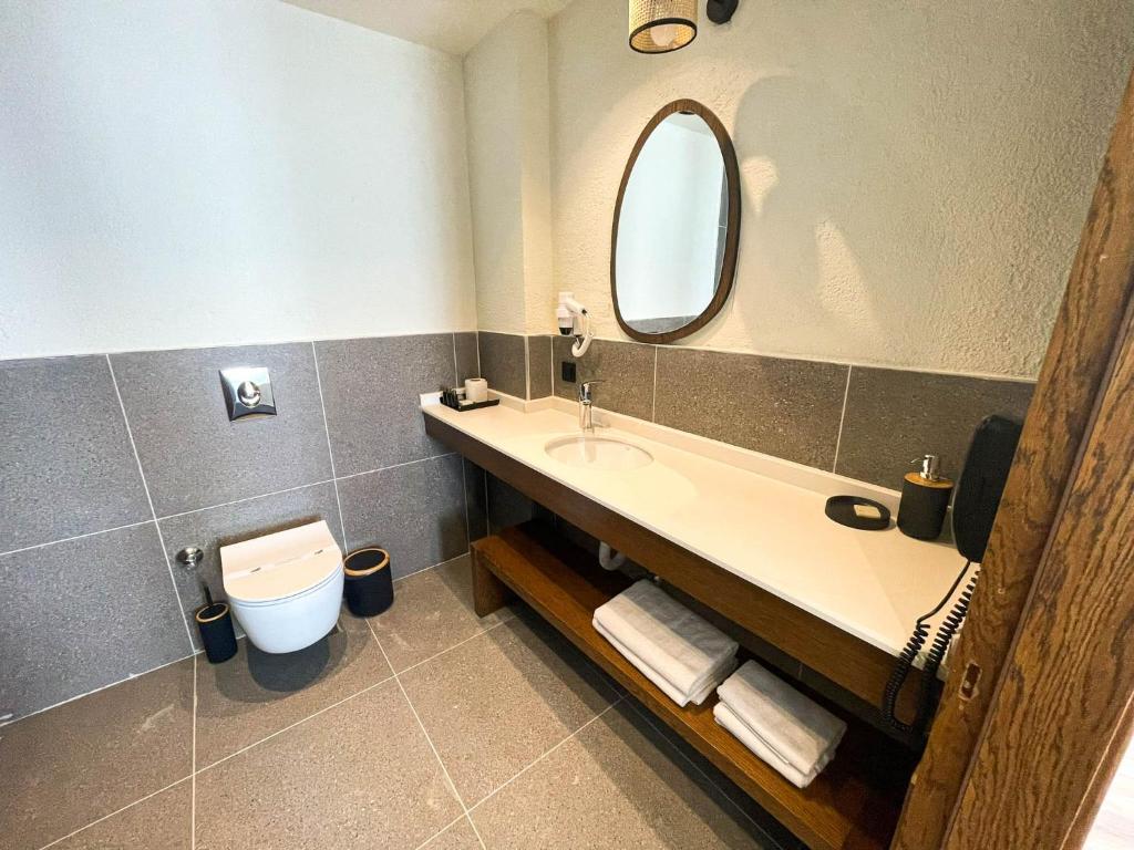 a bathroom with a sink and a toilet and a mirror at Now Boutique Hotel in Erdemli