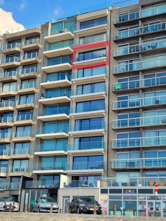 an apartment building with cars parked in front of it at residentie NAUSICAA in Blankenberge