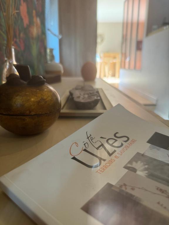 ein Buch auf einem Tisch mit einer Vase in der Unterkunft Le diX - Classic Room - VallabriX proche UZES in Vallabrix