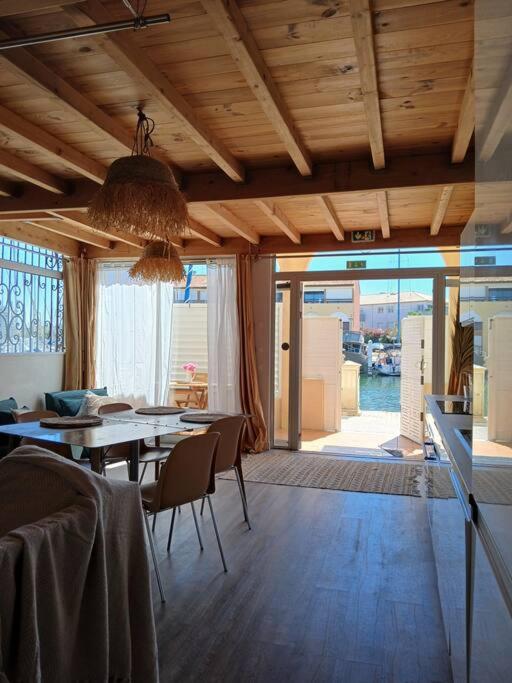 une salle à manger avec une table et des chaises et une grande fenêtre dans l'établissement Port et Plage, à Carnon-Plage