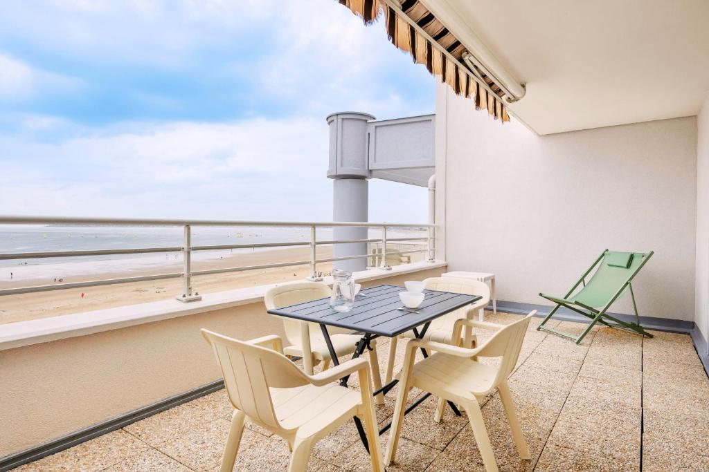 une table et des chaises sur un balcon avec vue sur l'océan dans l'établissement Vue mer - appartement pour 4, à Pornichet