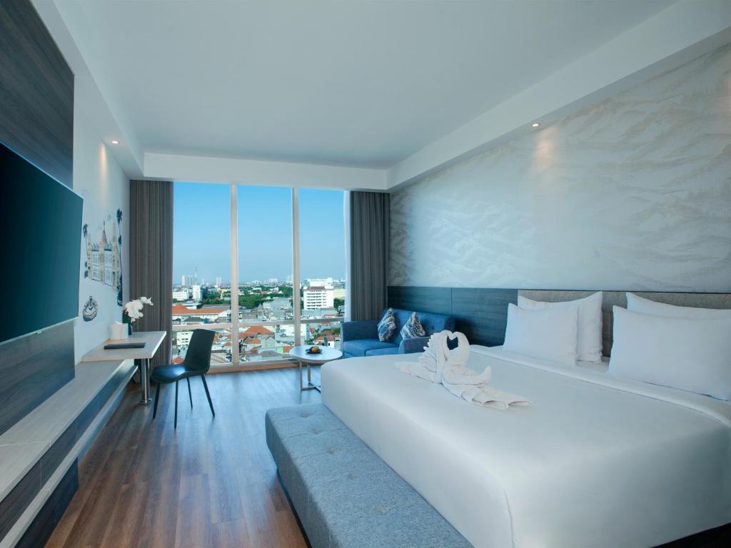 Postel nebo postele na pokoji v ubytování Platinum Hotel Tunjungan Surabaya