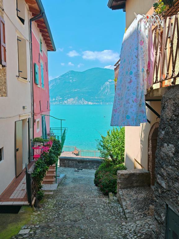 a street between two buildings with a view of a lake at Casa Rosa Rosadalake in Brenzone sul Garda