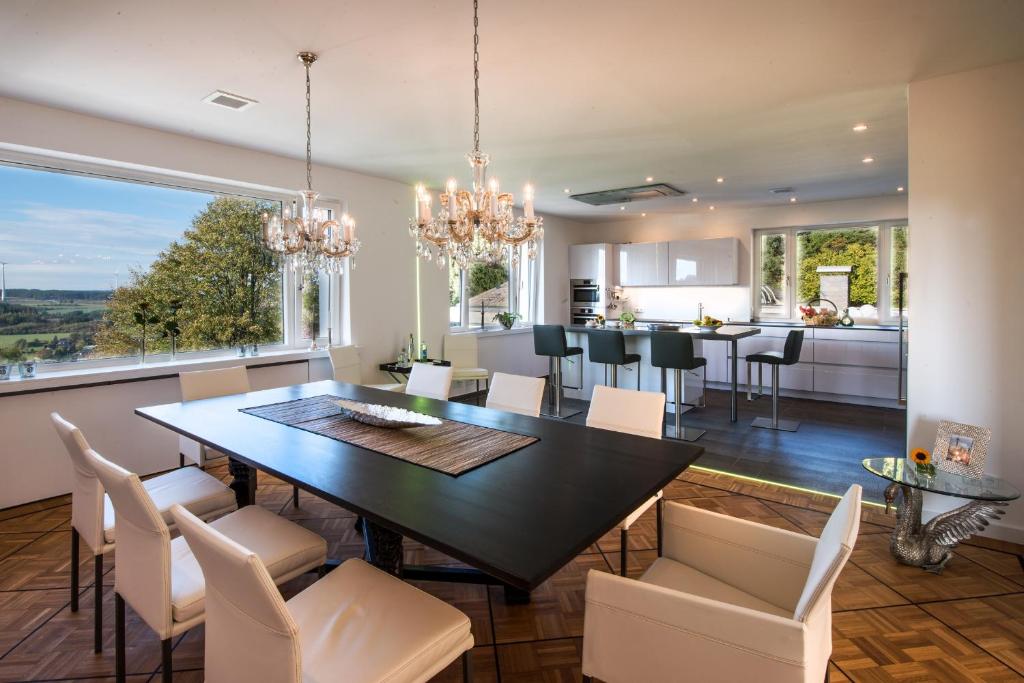 a dining room and kitchen with a table and chairs at View & Garden Villa Schauenstein in Schauenstein
