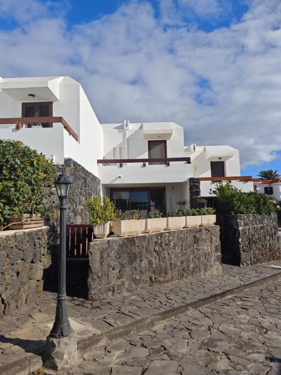 a house with a stone wall and a street light at Mirador de Las Salinas in Los Cancajos