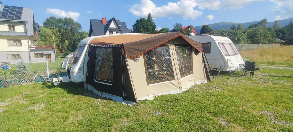 a tent and a van parked in a yard at Kemping Pod Babią Górą in Zawoja