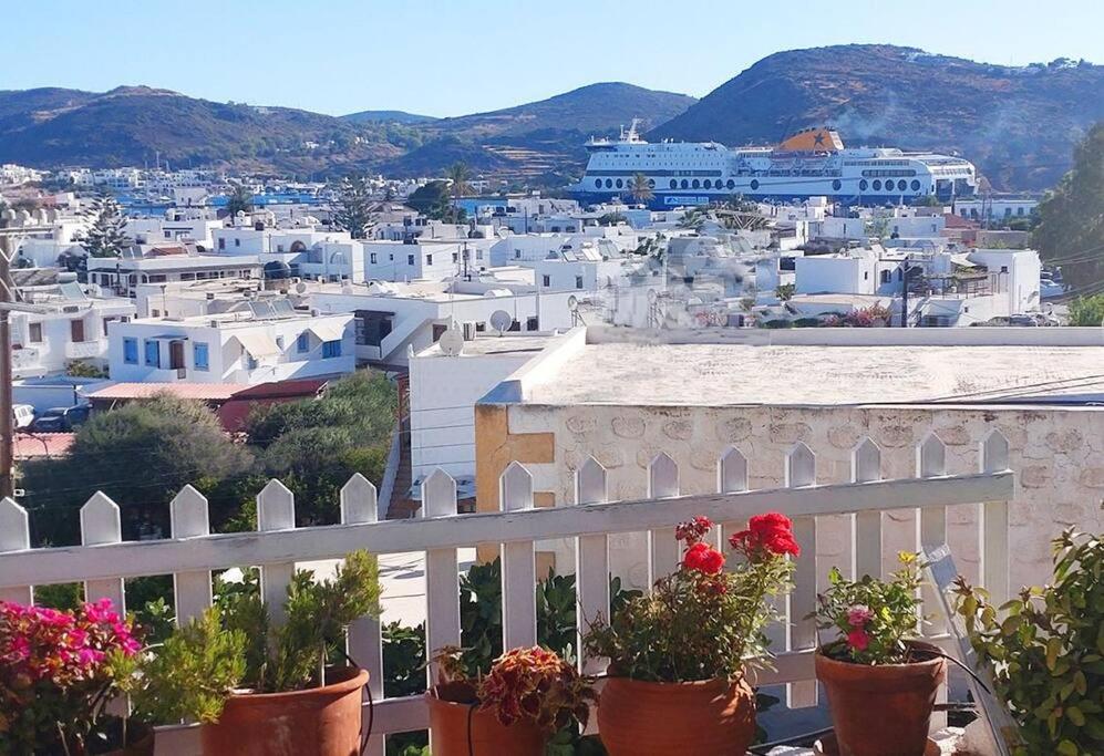 a view of a city from a balcony with potted plants at Chrisi's and Jasmin's house in Patmos