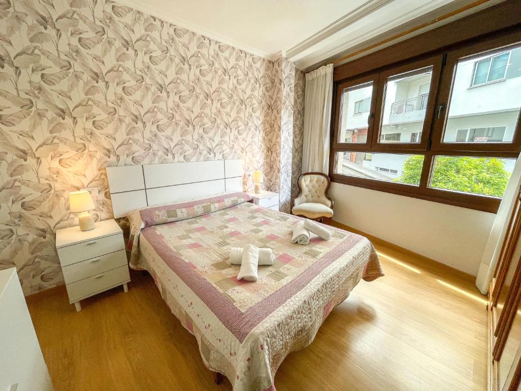 ポルトノボにあるApartamentos Portonovo 3000のベッドと窓のある寝室