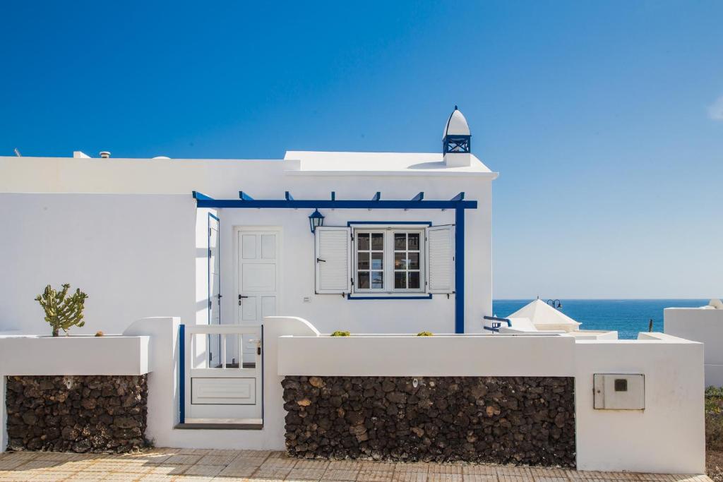 un edificio blanco y azul con ventana en Casa La Marea, en Arrieta