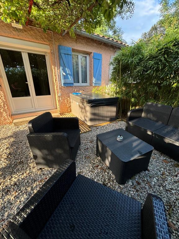 d'une terrasse avec des canapés, une table et une baignoire. dans l'établissement L'atelier cosy!, à Laroque