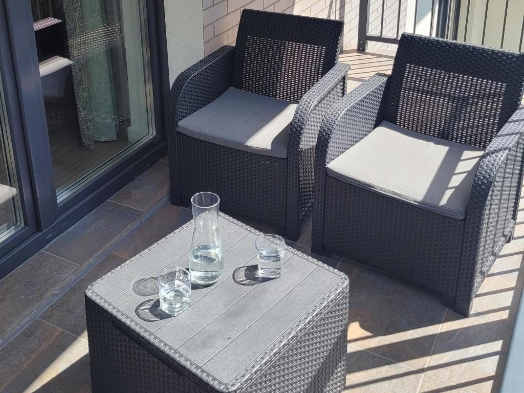 two chairs and a table with glasses on a porch at NATURA apartament in Malbork