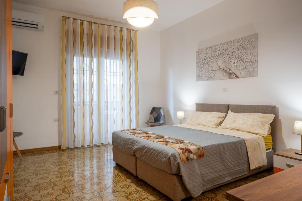 a bedroom with a bed and a large window at B&B Benvenuti al centro in Caserta