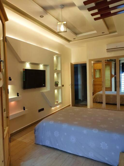 a bedroom with a bed and a flat screen tv at Appartement Calme a Marrakech in Marrakech