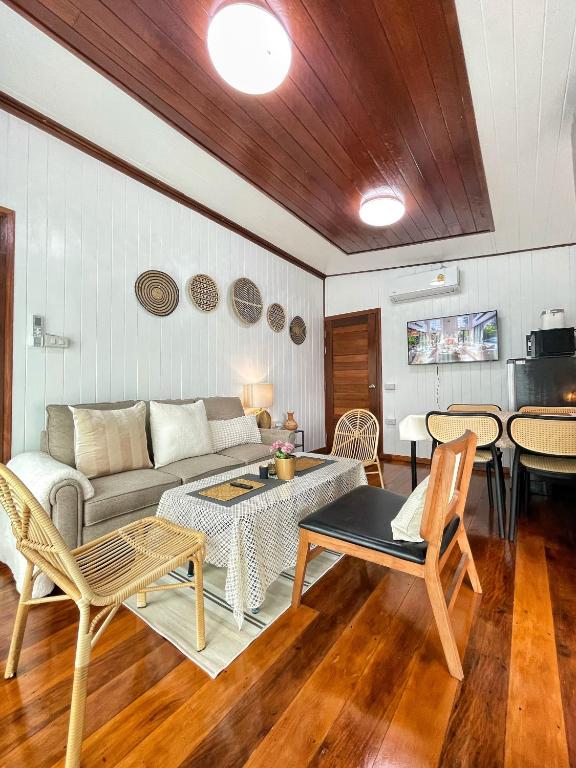 a living room with a couch and a table and chairs at Anna River Home A1 in Ban Khlong Si