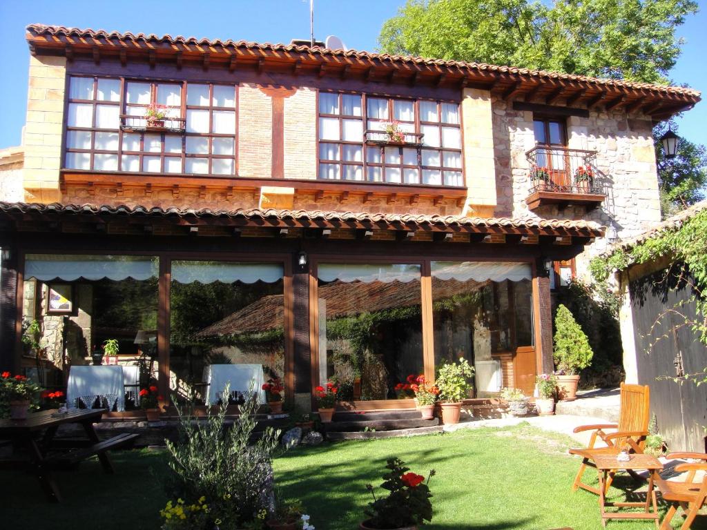 a house with a patio and a yard at Posada Rural Fontibre in Fontibre