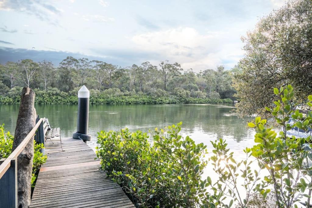 a wooden boardwalk leading to a river with trees at East Hills Waterfront Bliss in East Hills