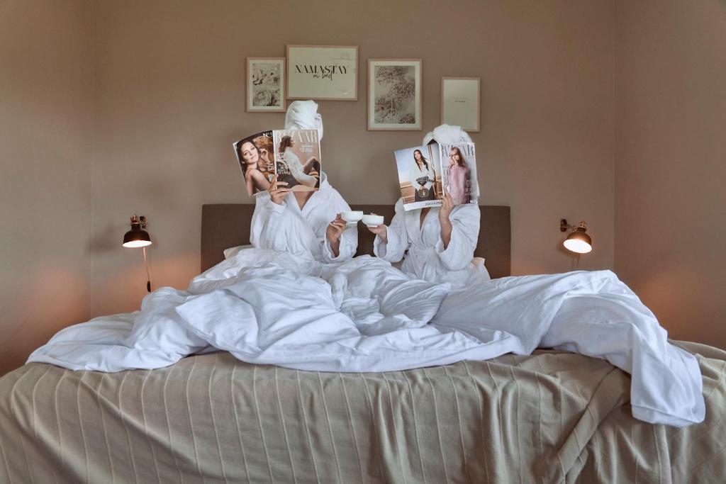 a group of people laying in bed with photos on them at MANA LISA Boutiquehotel in Lauda-Königshofen