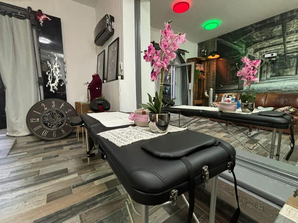 - un salon avec une table, des chaises et des fleurs roses dans l'établissement Cocon love port de l estaque, à Marseille