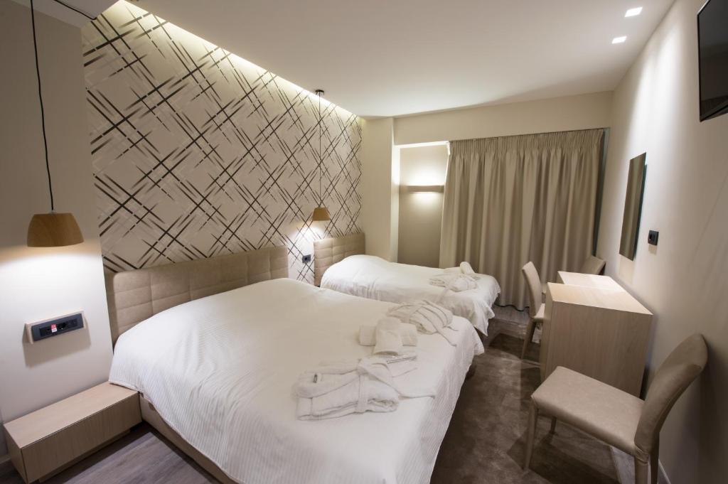 Pokój hotelowy z 2 łóżkami i krzesłem w obiekcie Castello City w mieście Patras