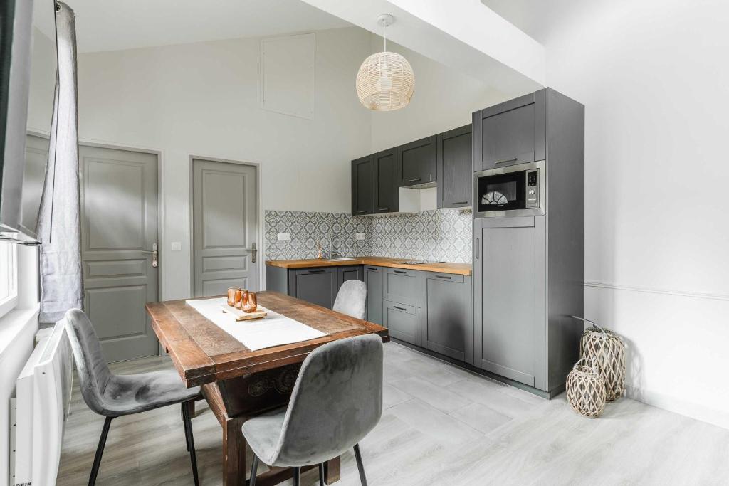 une cuisine avec une table et des chaises en bois dans l'établissement Townhouse with garden 100m from Place Morny, à Deauville