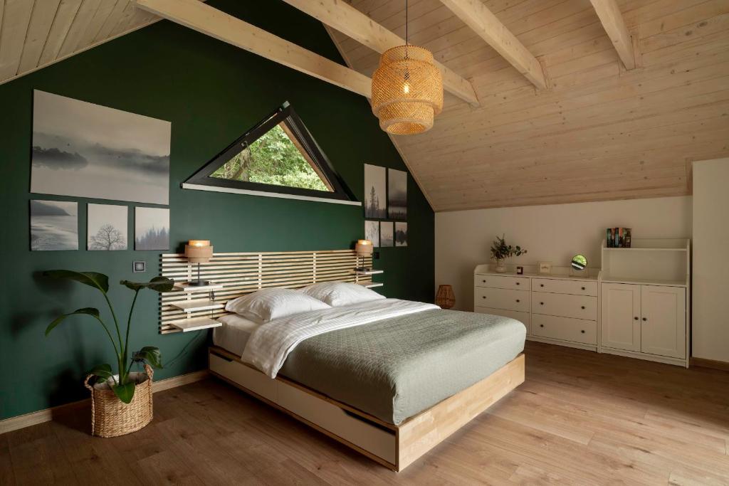 ein Schlafzimmer mit einem großen Bett und einer grünen Wand in der Unterkunft Okno na Beskidy in Maków Podhalański