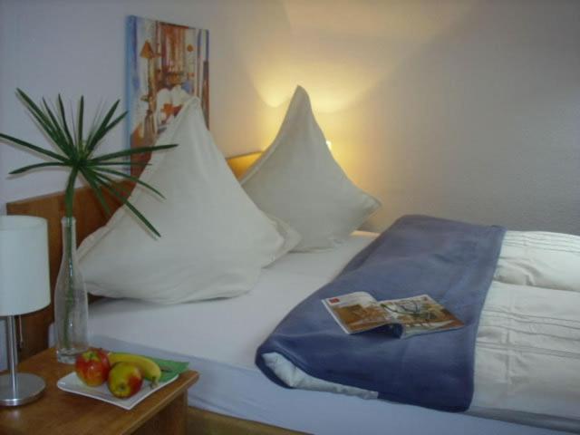 a bed with a tray of fruit on a table at Hotel Garni Zentral in Willich