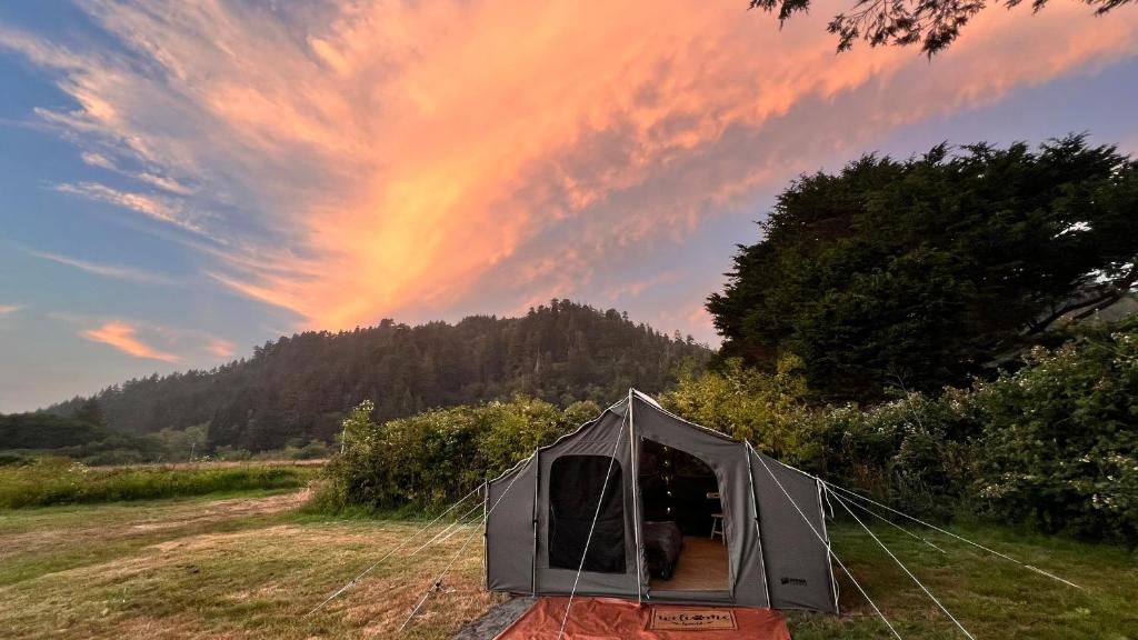 a tent in a field with a rainbow in the sky at Vista Glamping Tent in Klamath