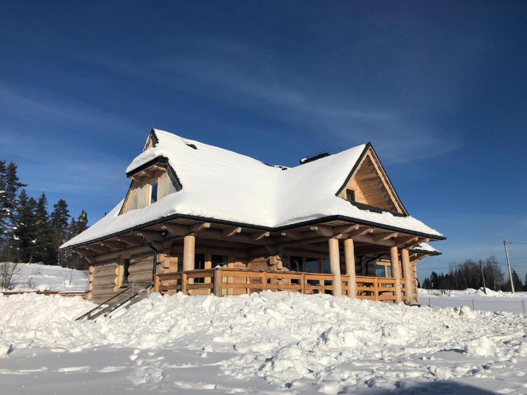 una baita di tronchi con tetto ricoperto di neve di Znak Gór a Czorsztyn