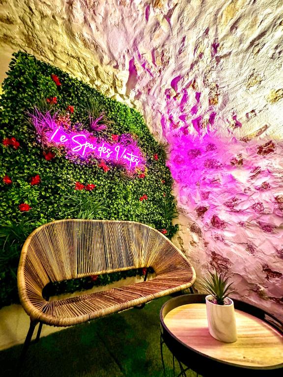 un banc et une table devant un mur avec des fleurs dans l'établissement Logement entier Le Spa des Voutes Jacuzzi Cinéma, à Saint-Maximin-la-Sainte-Baume