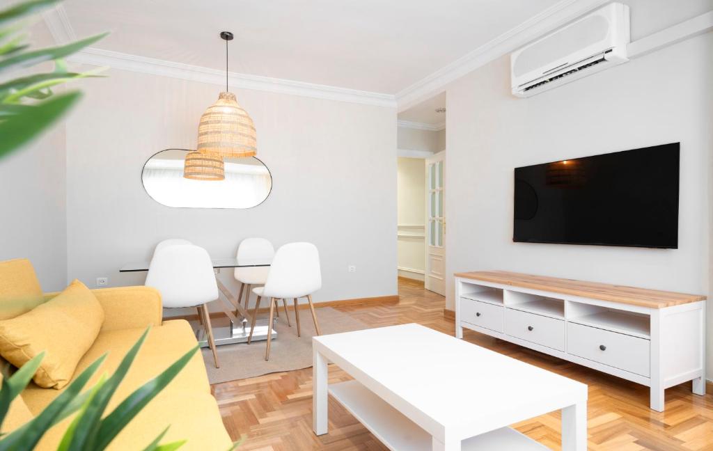 a living room with a tv and a table at EnjoyGranada RECOGIDAS HOMES in Granada