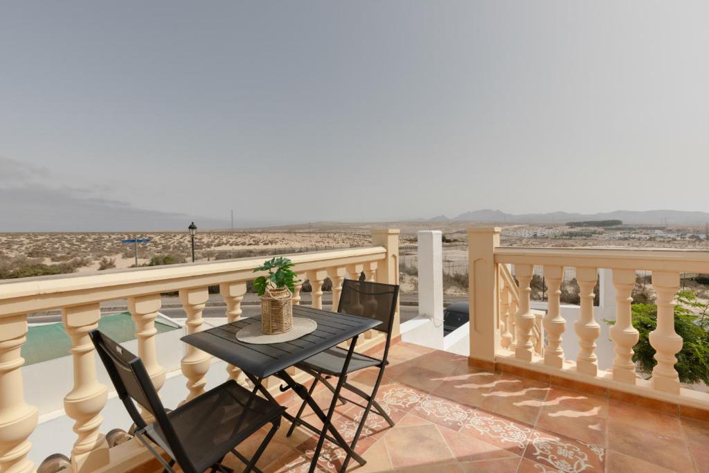a balcony with a table and chairs and the ocean at Las Arenas Family in Costa Calma